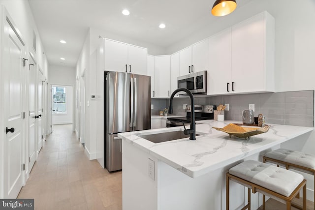1810 Federal St Unit 1, Philadelphia, PA 19146 - kitchen with appliances with stainless steel finishes, a peninsula, recessed lighting, light stone countertops, and tasteful backsplash