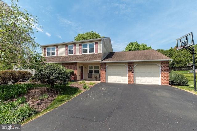 traditional-style house with driveway, brick siding, and an attached garage