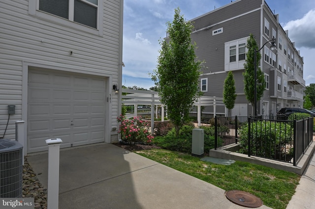 543 Leftwich Ln, Annapolis, MD 21401 - view of side of property with central AC unit, fence, driveway, and a garage