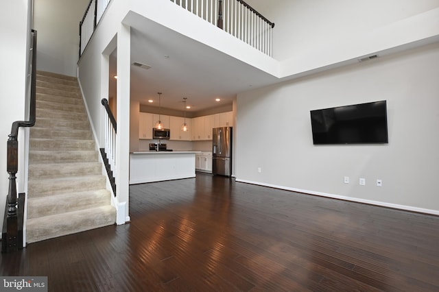 543 Leftwich Ln, Annapolis, MD 21401 - unfurnished living room with dark wood-style floors, stairs, baseboards, and recessed lighting