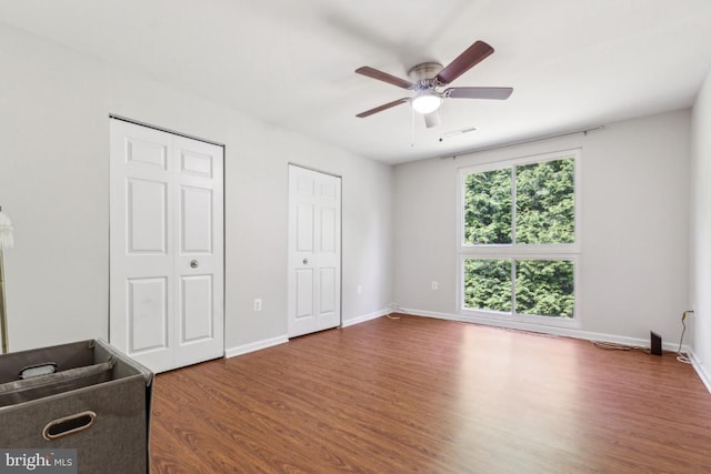 5608 Bismach Dr Unit 103, Alexandria, VA 22312 - unfurnished bedroom with dark wood-style floors, multiple closets, ceiling fan, baseboards, and visible vents