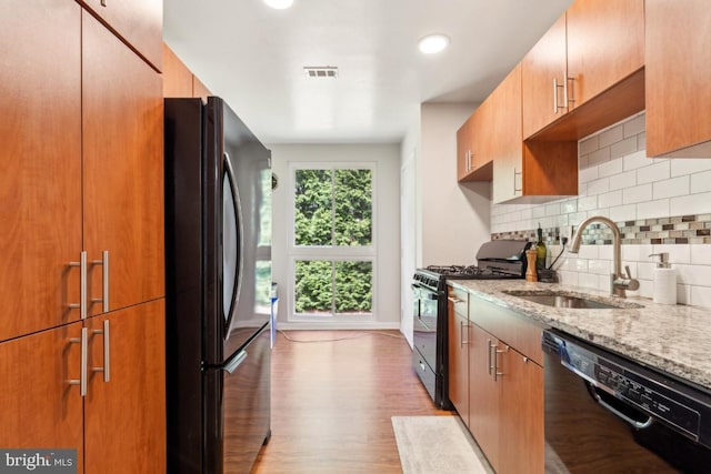5608 Bismach Dr Unit 103, Alexandria, VA 22312 - kitchen featuring light stone counters, tasteful backsplash, a sink, black appliances, and visible vents