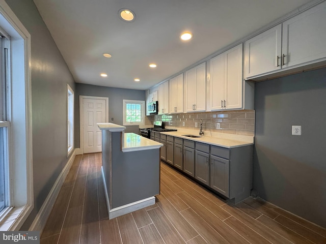 kitchen featuring light countertops, gray cabinetry, appliances with stainless steel finishes, and a center island