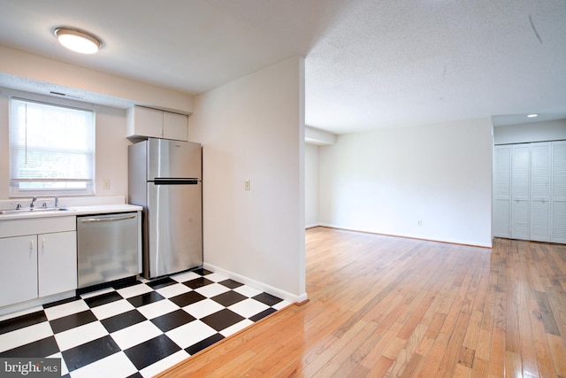 11902 Tarragon Rd Unit J, Reisterstown, MD 21136 - kitchen with appliances with stainless steel finishes, a sink, baseboards, light countertops, and white cabinetry