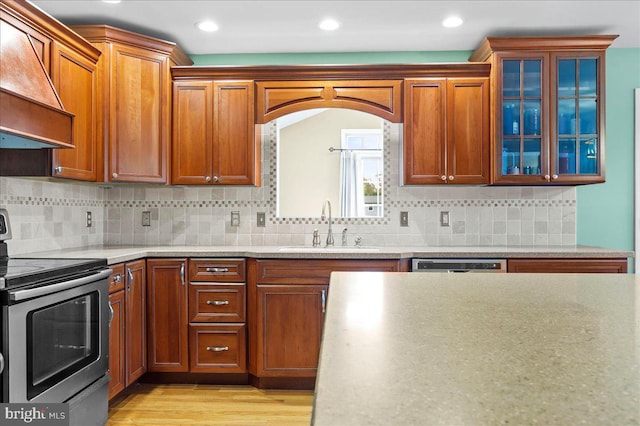 128 Pinion Pl, Bear, DE 19701 - kitchen featuring a sink, premium range hood, light wood-type flooring, brown cabinetry, and appliances with stainless steel finishes