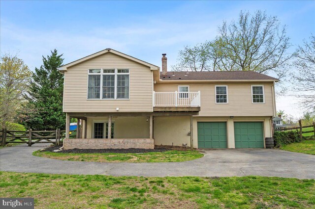 128 Pinion Pl, Bear, DE 19701 - view of front facade with a chimney, fence, a garage, a balcony, and aphalt driveway