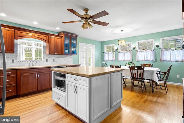 128 Pinion Pl, Bear, DE 19701 - kitchen with stainless steel microwave, a sink, light countertops, and light wood-style floors