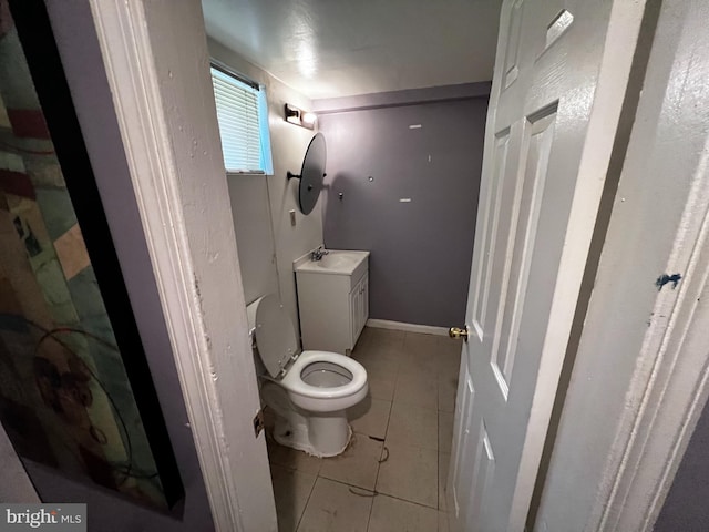 bathroom with toilet, tile patterned floors, and vanity