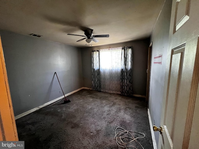 unfurnished room with ceiling fan, visible vents, baseboards, and dark colored carpet