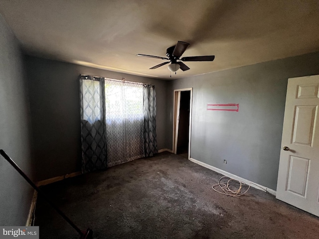 carpeted spare room with baseboards and a ceiling fan