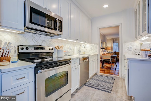 3275 Sutton Pl NW Unit C, Washington, DC 20016 - kitchen featuring tasteful backsplash, appliances with stainless steel finishes, light countertops, white cabinets, and a sink