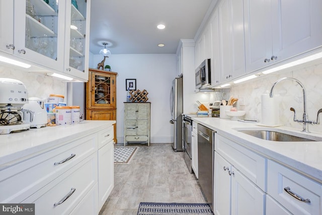 3275 Sutton Pl NW Unit C, Washington, DC 20016 - kitchen with white cabinetry, tasteful backsplash, a sink, stainless steel appliances, and light countertops