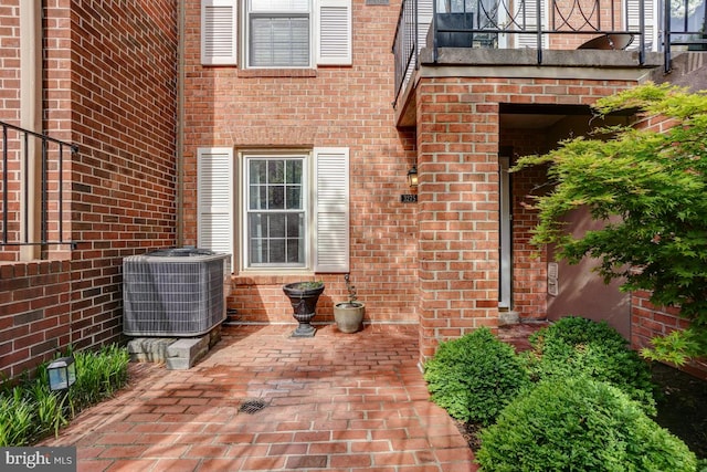 3275 Sutton Pl NW Unit C, Washington, DC 20016 - view of exterior entry with a patio, central air condition unit, and brick siding
