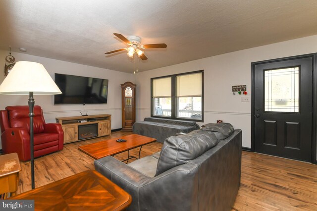 living room featuring wood finished floors, ceiling fan, and plenty of natural light