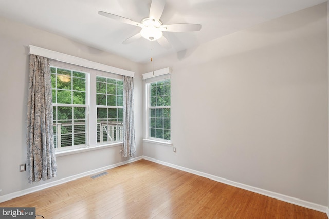 unfurnished room with wood finished floors, ceiling fan, and baseboards