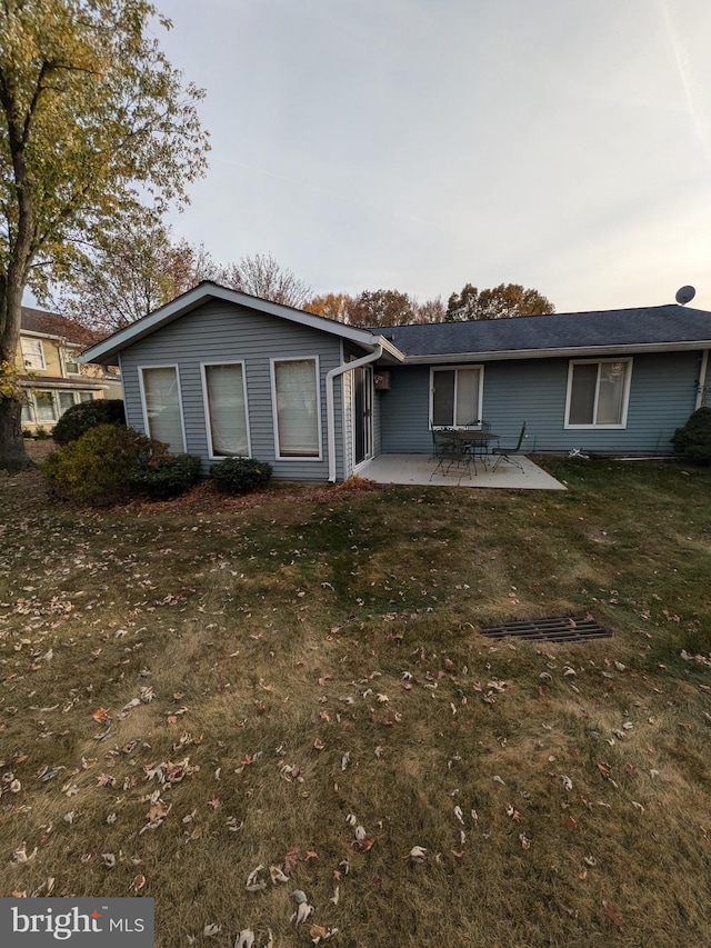 view of front of home with a front yard and a patio
