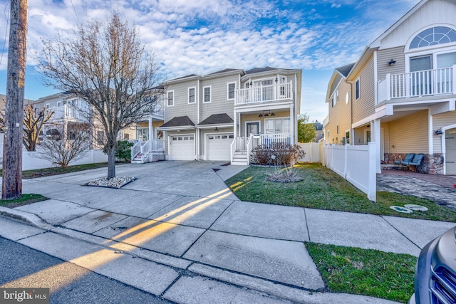 view of front facade featuring driveway, covered porch, fence, an attached garage, and a balcony