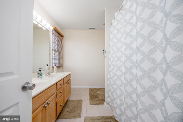 bathroom featuring tile patterned floors, visible vents, a sink, and double vanity