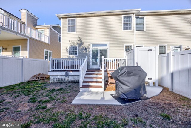 rear view of house featuring a fenced backyard and a deck