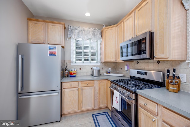 kitchen featuring light brown cabinets, appliances with stainless steel finishes, and tasteful backsplash
