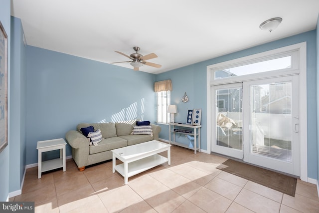 living room with tile patterned floors, baseboards, and ceiling fan