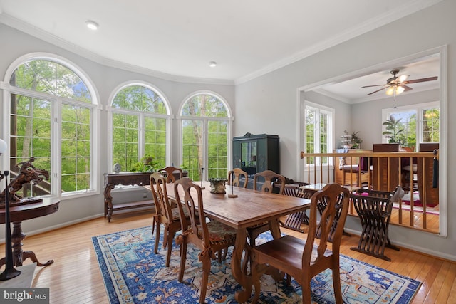 dining space featuring baseboards, crown molding, and light wood-style flooring