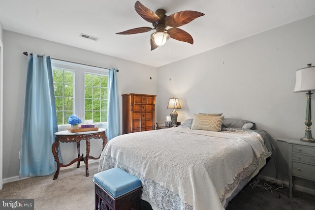 bedroom featuring a ceiling fan, visible vents, light carpet, and baseboards