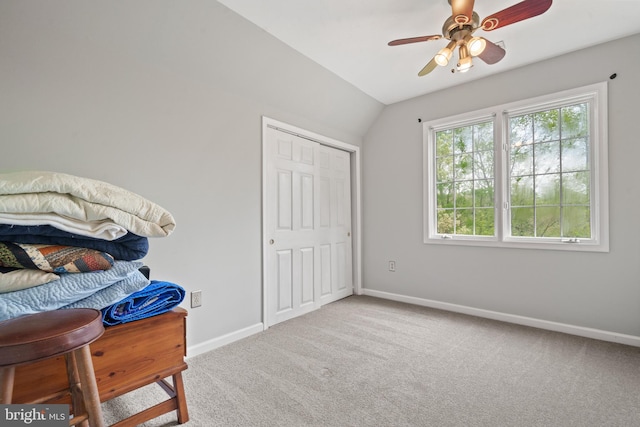 carpeted bedroom featuring baseboards, ceiling fan, a closet, and vaulted ceiling