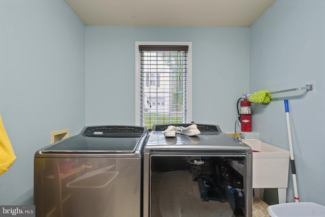laundry room featuring washing machine and dryer, tile patterned flooring, a sink, and laundry area