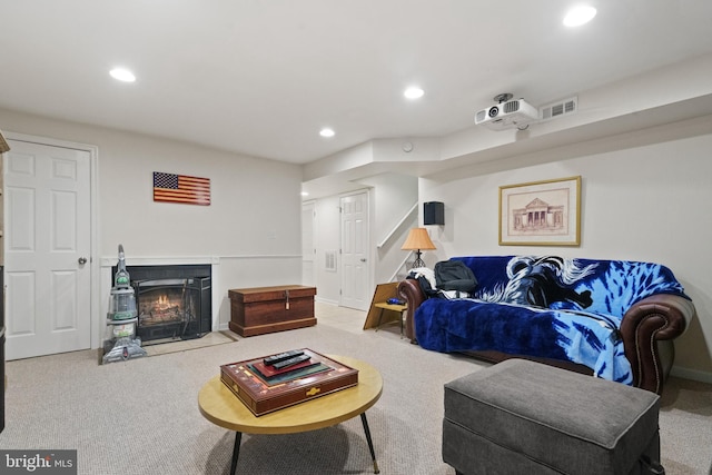 living room with carpet flooring, recessed lighting, visible vents, and a fireplace with flush hearth