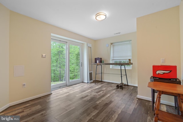 empty room featuring visible vents, wood finished floors, and baseboards
