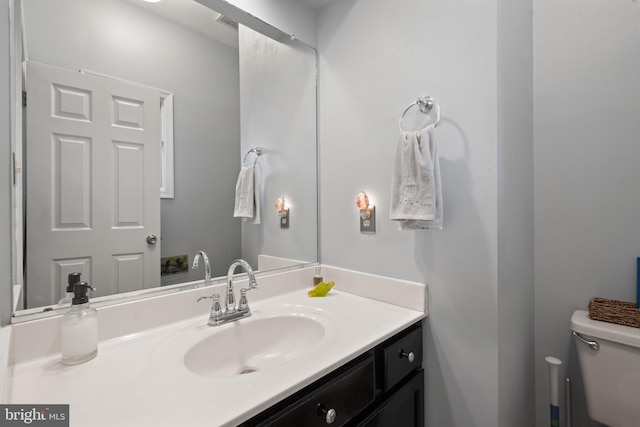 half bathroom with toilet and vanity