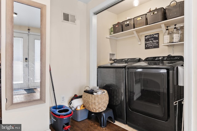 laundry area featuring laundry area, french doors, visible vents, washing machine and dryer, and wood finished floors