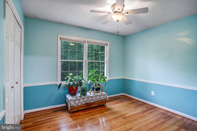 4985 Tall Oaks Dr, Monrovia, MD 21770 - living area featuring a textured ceiling, wood finished floors, baseboards, and ceiling fan