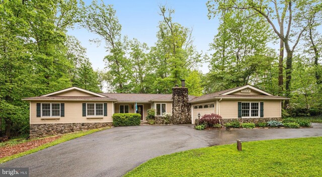 4985 Tall Oaks Dr, Monrovia, MD 21770 - single story home featuring stone siding, a chimney, a garage, and aphalt driveway