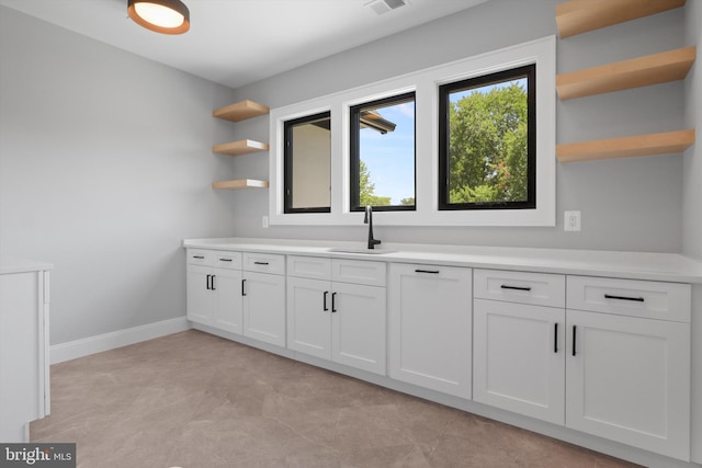 bar with visible vents, baseboards, and a sink