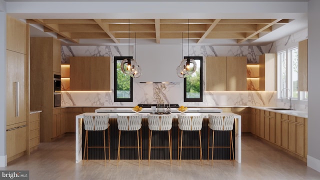 kitchen with a sink, backsplash, coffered ceiling, and a kitchen island