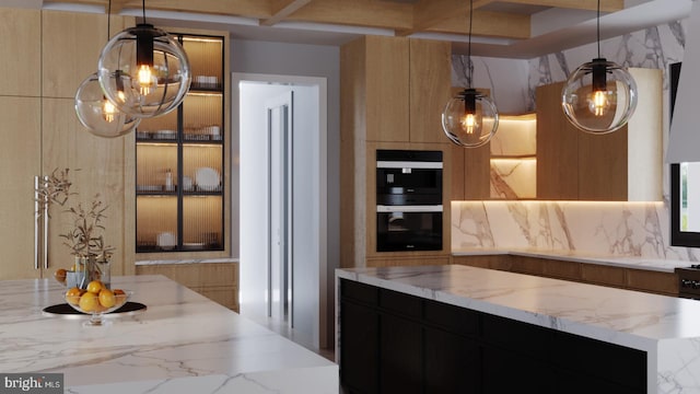 kitchen featuring dark cabinets, modern cabinets, dobule oven black, and light stone counters