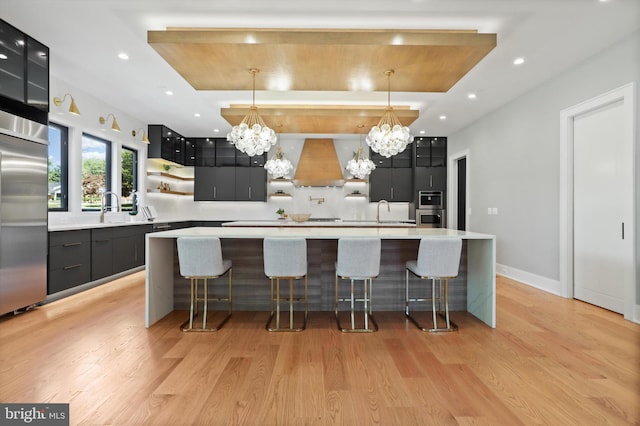 kitchen featuring open shelves, wall chimney exhaust hood, dark cabinetry, and modern cabinets