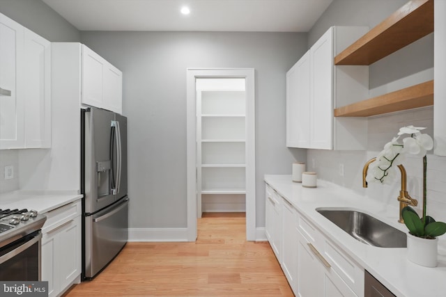 kitchen featuring white cabinets, appliances with stainless steel finishes, and open shelves