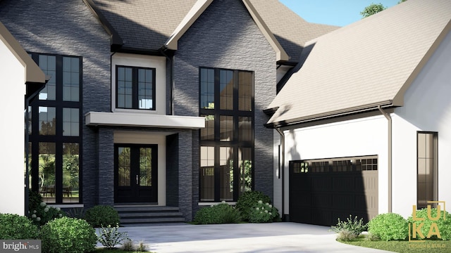 view of front of home with stucco siding, driveway, french doors, stone siding, and a garage