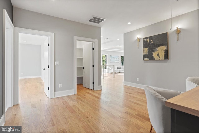 hallway featuring light wood-type flooring, baseboards, visible vents, and recessed lighting
