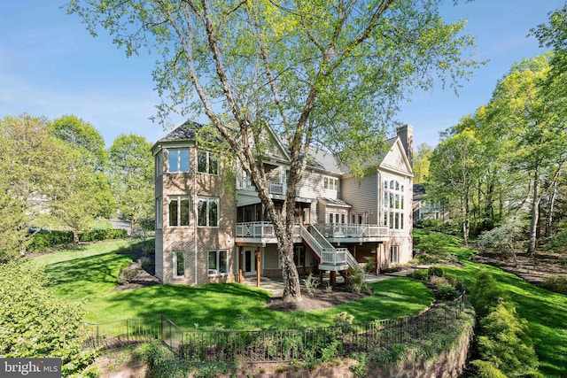 rear view of property with a deck, a chimney, a yard, stairway, and fence private yard