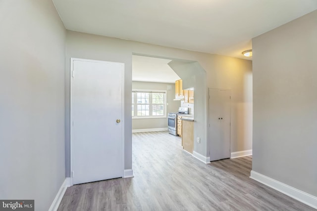 unfurnished room with light wood finished floors and baseboards