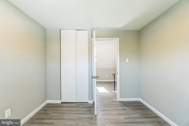 interior space featuring baseboards, wood finished floors, and a closet
