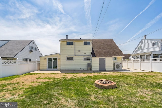 back of property with an outdoor fire pit, a fenced backyard, a yard, ac unit, and a patio area