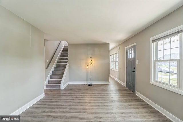entryway featuring stairway, wood finished floors, and baseboards