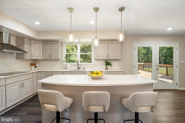 4 Brian Daniel Ct, Reisterstown, MD 21136 - kitchen featuring wall chimney range hood, black electric stovetop, a breakfast bar, decorative backsplash, and recessed lighting