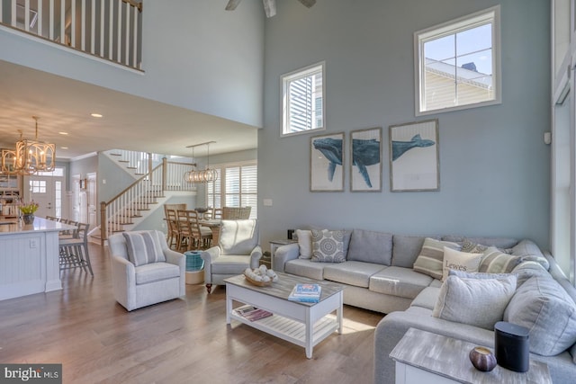 11520 Maull Rd Unit S-183, Lewes, DE 19958 - living room with ceiling fan with notable chandelier, stairs, a towering ceiling, and wood finished floors
