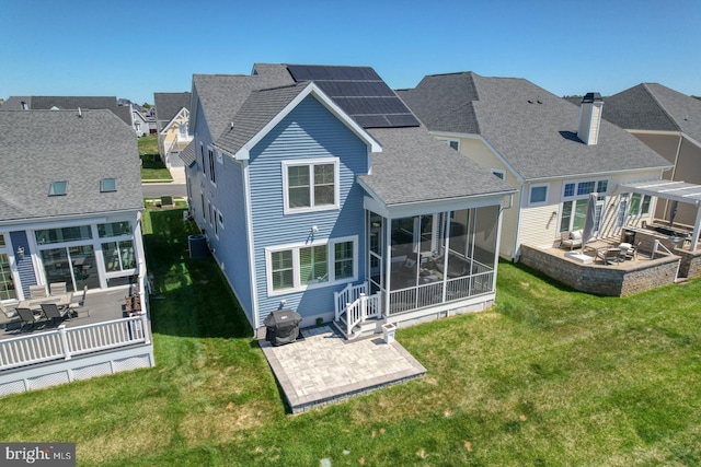11520 Maull Rd Unit S-183, Lewes, DE 19958 - back of property with roof with shingles, a sunroom, a patio area, roof mounted solar panels, and a yard